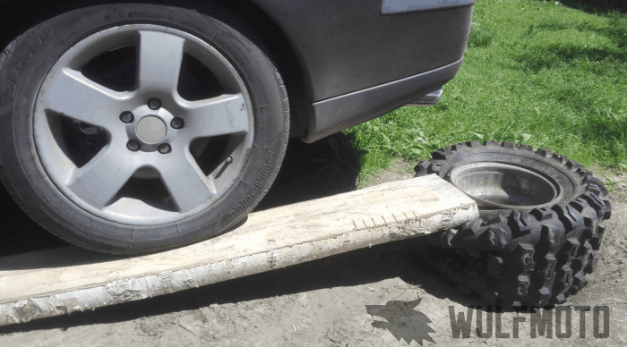 Breaking the bead of an ATV tire by driving over it with a car.